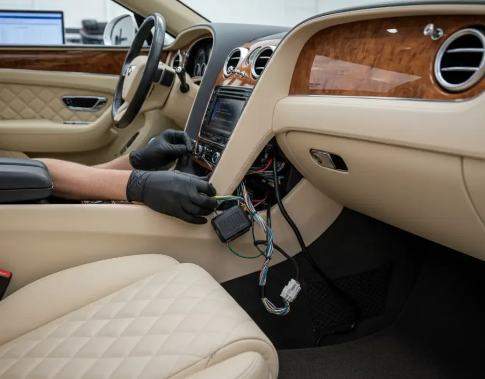 Technician installing ghost immobiliser inside Bentley Continental GT in UK workshop