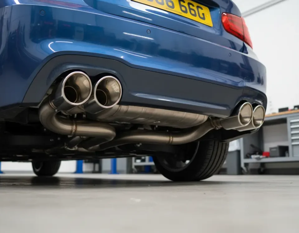 Custom stainless steel exhaust with polished dual tips on BMW 116i in UK workshop